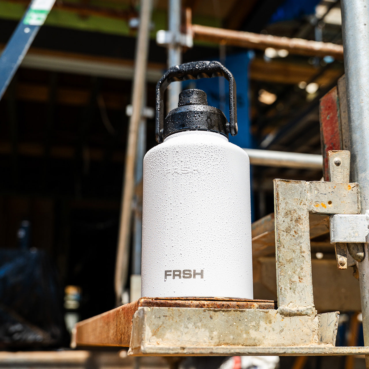 FRSH 3.8L bottle with chug lid, durable water bottle for sports and outdoor activities, black with textured grip.