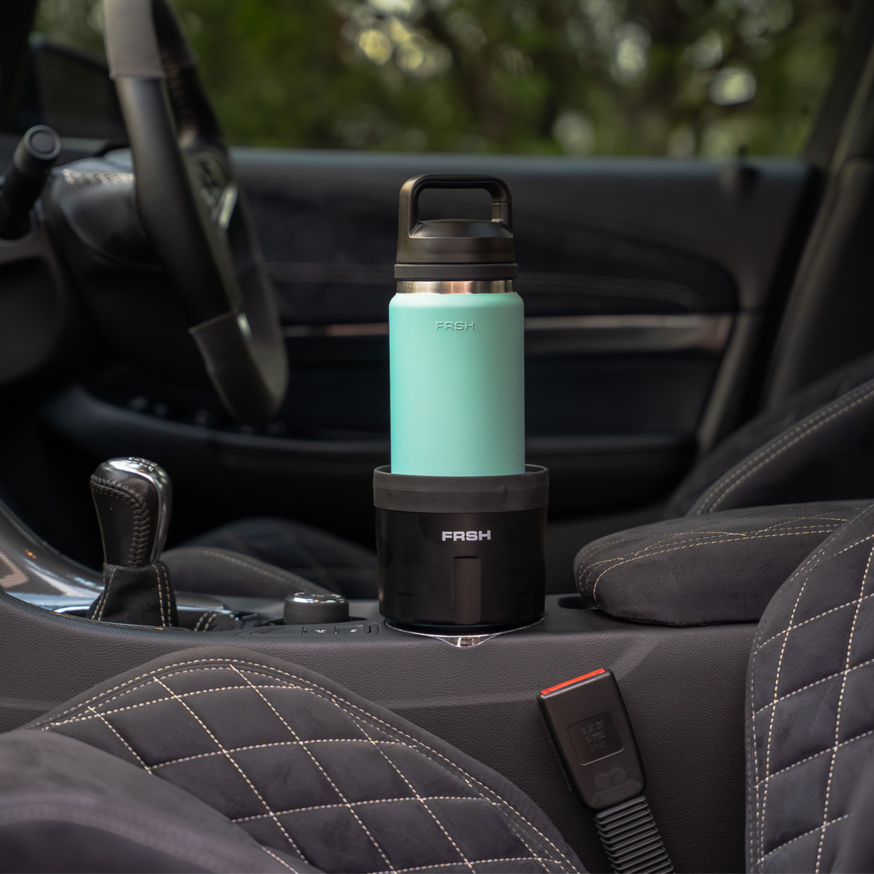 FRSH car bottle holder attached to a vehicle interior, designed to securely hold water bottles during drives.